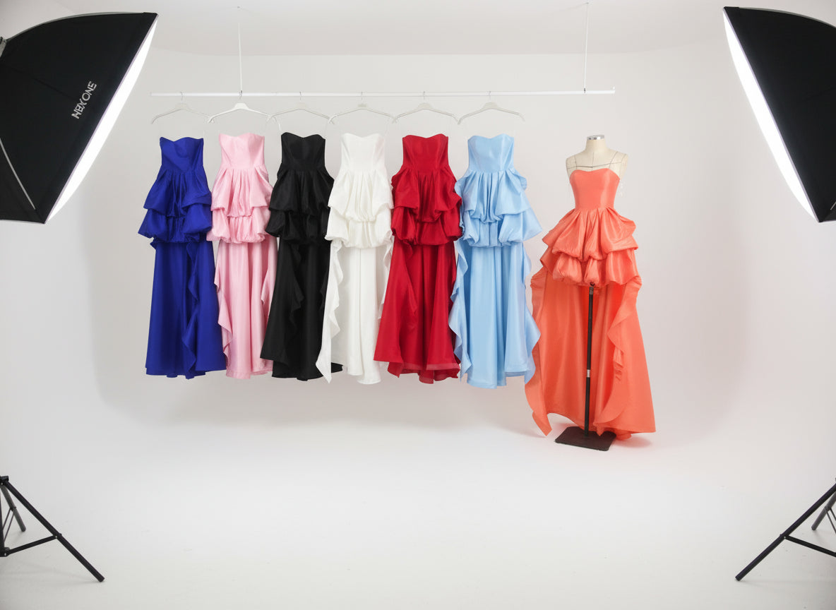 Set of colorful dresses on mannequins against a white background